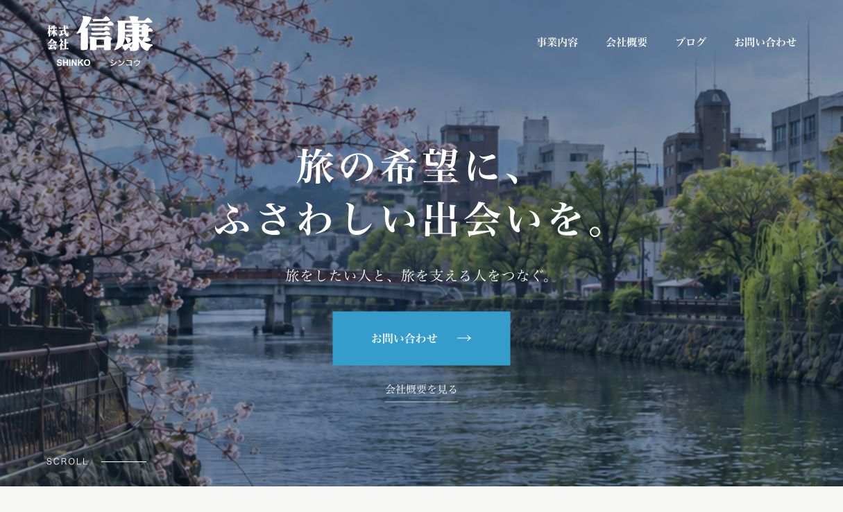 株式会社信康の公式サイトのトップページ。川沿いの桜と「旅の希望に、ふさわしい出会いを。」のメッセージ。